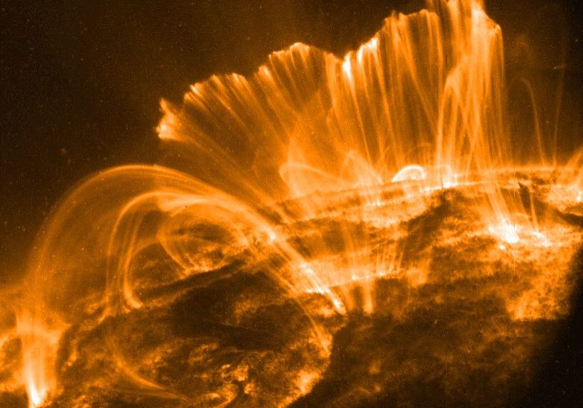 In this picture, the Sun's surface is quite dark. A frame from a movie recorded on November 9th by the orbiting TRACE telescope, it shows coronal loops lofted over a solar active region. Glowing brightly in extreme ultraviolet light, the hot plasma entrained above the Sun along arching magnetic fields is cooling and raining back down on the solar surface.